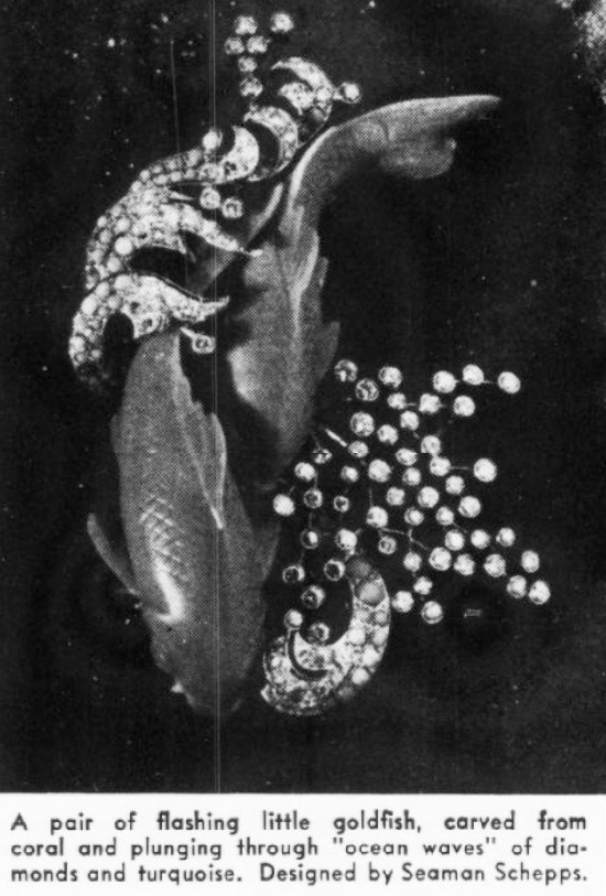 A pair of flashing little goldfish, carved from coral and plunging through 'ocean waves' of diamonds and turquoise. November 1954