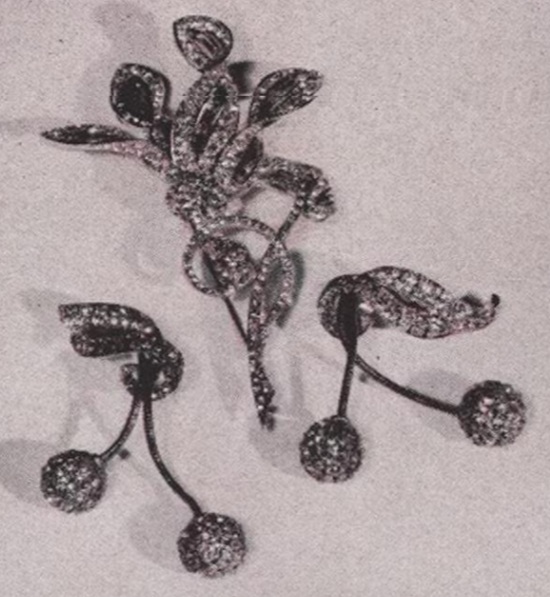 Frosty rhinestone flower-pin with earrings matching. Vogue December 1940 ad