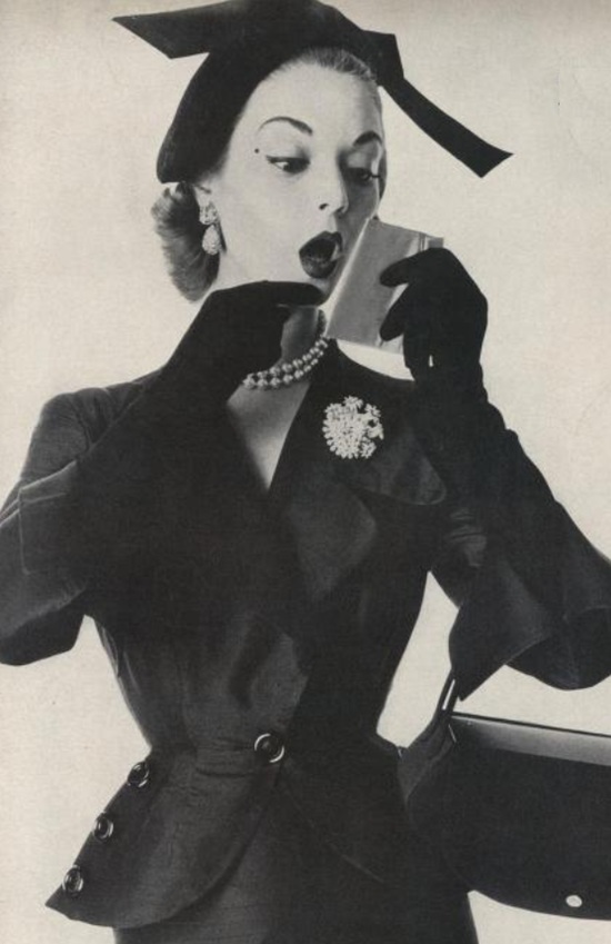 The suit, hat by Adele Simpson, diamond-flowered pear! pin and earrings, from Schlumberger. Vogue February 1951 ad